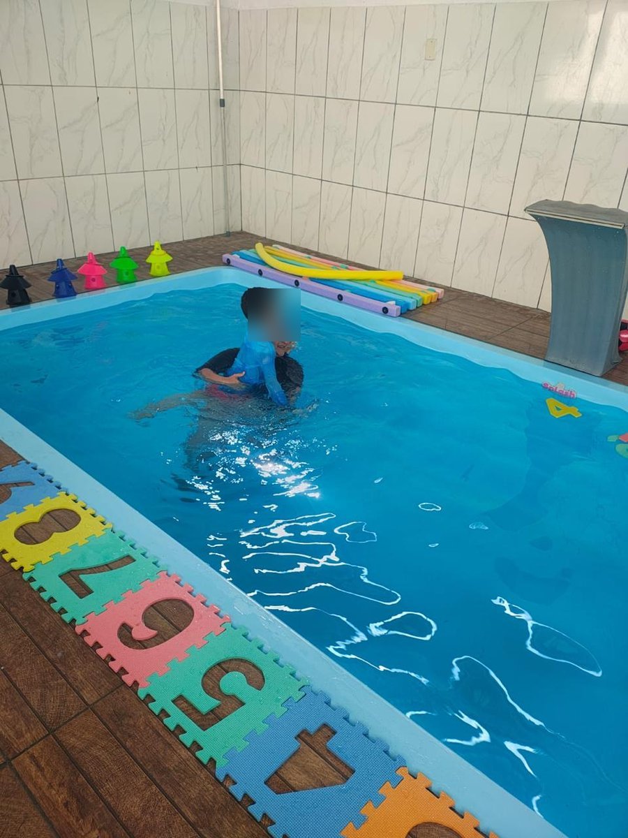 Atendimento na piscina da TEA Encantar com materiais lúdicos